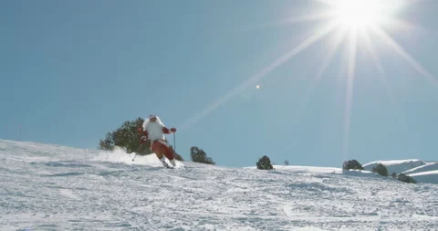 Bearded old man in red Santa Clause clothing skiing on snowy track in winter Видео 136487209