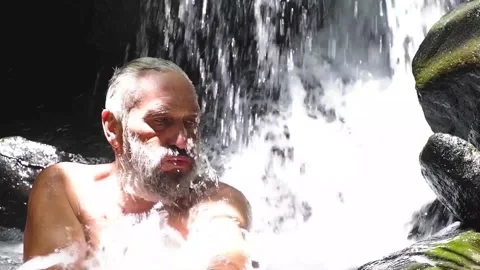 Bearded old man washes in the river Stock Footage