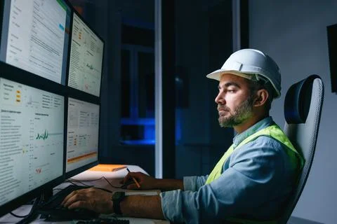 Bearded operator of factory control industry process using monitors. Engineer Stock Photos