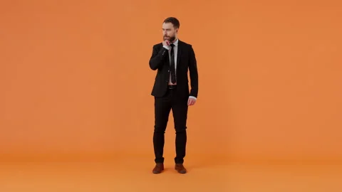 Bearded pensive guy in formal suit, holding hand on face, reasoning over problem Stock Footage 259500574