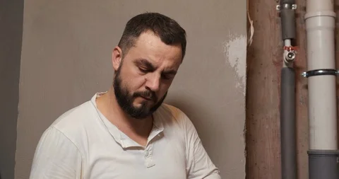 Bearded plumber working at construction site, remodeling sewer pipes, apartment Stock Footage 126308585