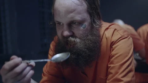 Bearded prisoner eating at the canteen Stock Footage 283079349