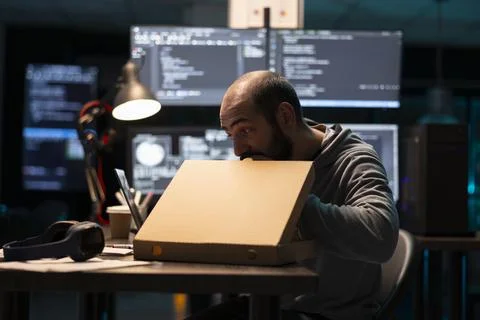 Bearded Programmer Eating Pizza During Night Shift Stock-Fotos