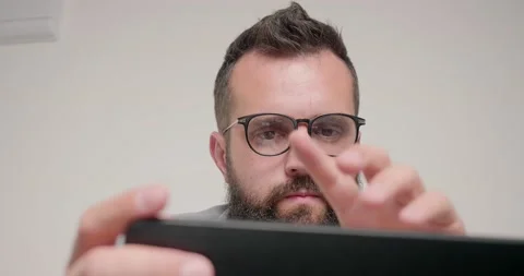 Bearded programmer works on laptop sitting in office Stock Footage 197466529