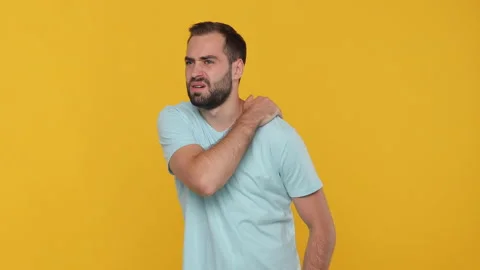 Bearded sad young man in basic casual blue t-shirt isolated on yellow background Stock Footage 148287507