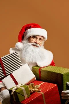 Bearded Santa Claus posing in studio with lots of presents Stock Photos