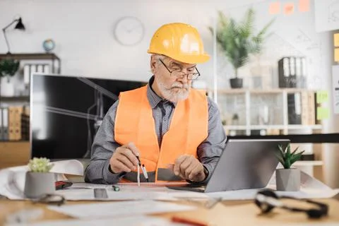 Bearded senior man controlling working process. Stock Photos
