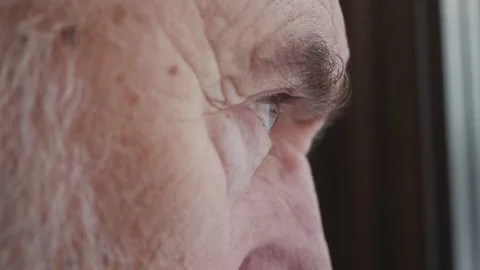 Bearded senior man looking to outside from window. Lonely old man looking into d Stock Footage 148944936