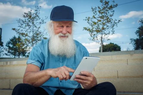 Bearded senior man using tablet Stock Photos