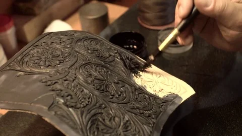 Bearded skinner covers a piece of leather with embossed flowers close-up 4k. Stock Footage 77882280