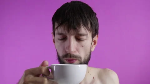 Bearded sleepy man drinks cup of coffee early in the morning Stock Footage 120563995