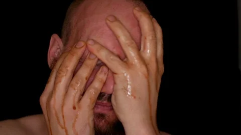 Bearded strange weird man touching his face, rubbing and brown liquid Stock Footage 112023050