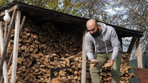 Bearded strong man with a log and a sharp vintage axe chop wood and put them Stock Footage 220720876