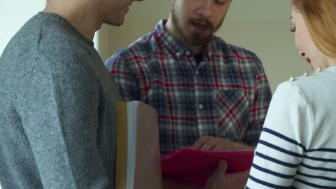Bearded student explaines to his classmates something in his notebook Stock-Footage 73638395