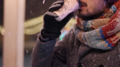 Bearded stylish man in gray coat and knitted scarf drinks coffee out of paper Stock Footage 118803260
