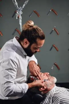 Bearded stylist testing new straight raizor Stock Photos