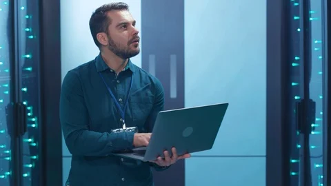 Bearded system administrator working on notebook inspecting operating database Stock Footage 119841898