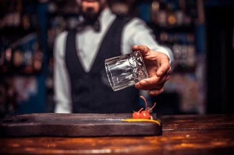Bearded tapster demonstrates the process of making a cocktail behind bar Stock Photos
