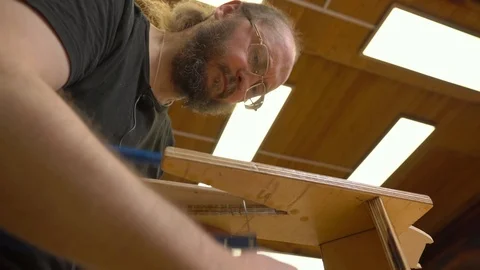 Bearded teacher in glasses cuts outdated jetliner model Stock Footage 126714683