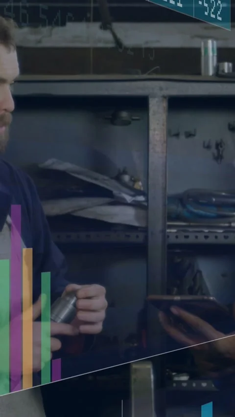 Bearded tech inspecting rotating metal part for fit while peer tapping tablet Stock Footage 331822369