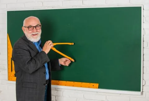 Bearded tutor man draw with compass on blackboard. back to school. Math graphic Stock Photos
