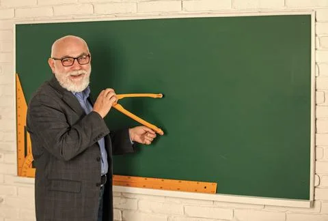 Bearded tutor man draw with compass on blackboard. back to school. Math graphic 스톡 사진