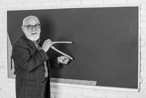 Bearded tutor man draw with compass on blackboard. back to school. Math graphic Stock Photos