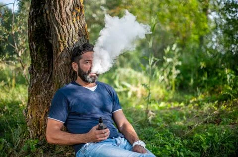 Bearded vaper blows up a couple an e-cigarette. Vaping. Foto stock