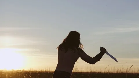 Bearded viking fulfills at sunset techniques with a knife. Amazing atmosphere. Stock Footage 108953759