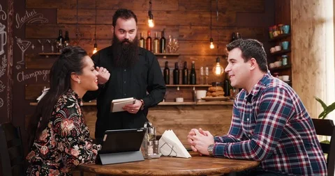 Bearded waiter taking order from couple Stock Footage 101110729