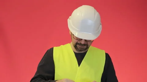 Bearded worker in white helmet raises head looking in camera Stock Footage 231780449