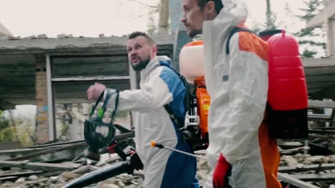 Bearded workers talk walking past abandoned ruined buildings Stock Footage 153757505