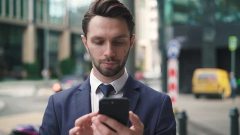 Bearded young businessman using his phone in city street Stock Footage 95591444