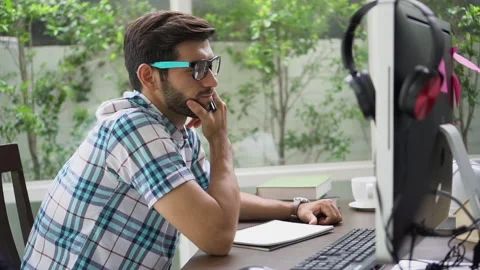 Bearded young  Freelancer man thinking and take a note on dask with computer Stock-Footage 134399111