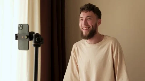 A bearded young guy communicates emotionally via video using a phone Stock Footage 278798422