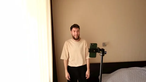 A bearded young guy communicates emotionally via video using a phone Stock Footage 278798531