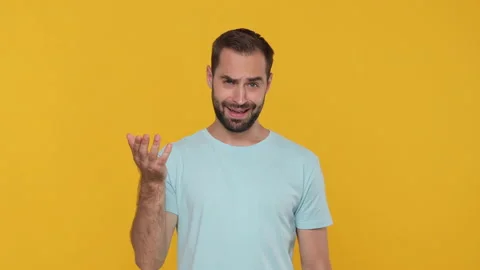 Bearded young man 20s in basic casual blue t-shirt isolated on yellow background Stock Footage 148287153