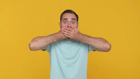 Bearded young man 20s in basic casual blue t-shirt looking at camera covering Stock Footage 148287318