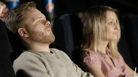 Bearded Young Man Falling Asleep During a Movie at the Cinema Stock Footage 71780836
