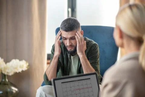Bearded young man sharing problems with psychoanalyst Stock Photos