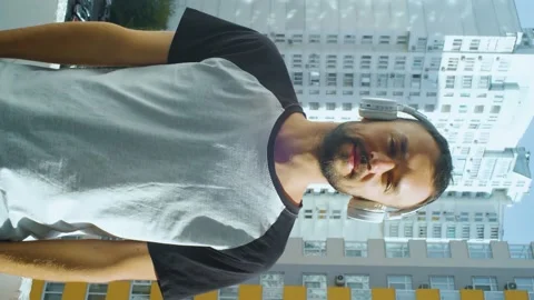 Bearded young man smiling on camera while standing on the balcony, and crossing Stock Footage 168716512