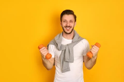 A bearded young mandoing exercises with two dumbbells Stock Photos