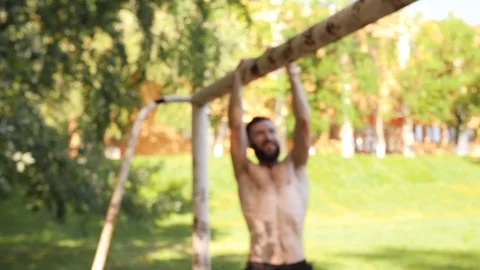 Bearded young muscular man doing pull-up exercisings on a crossbar of football Video stock 99162134