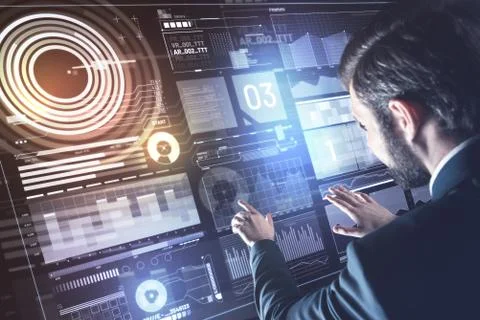 Bearded young programmer touching the transparent screen and thinking Stock-Fotos