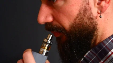 Beared man smoking electronic cigarette Stock Footage 72852584