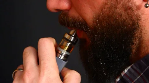 Beared man smoking electronic cigarette Stock Footage 72852587