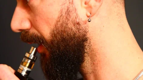 Beared man smoking electronic cigarette 動画素材 72852682