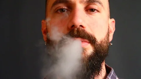Beared man smoking electronic cigarette Stock Footage 72853542