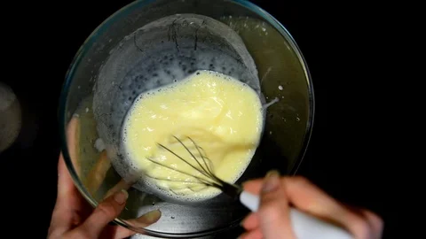 Beat the dough in a bowl on a dark table Stock Footage 124723559