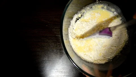 Beat the dough in a bowl on a dark table Stock Footage 124723655